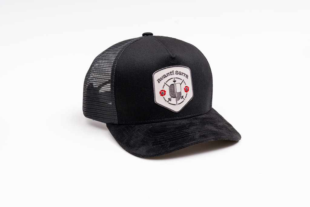Close-up of embroidered patch on black trucker hat front panel