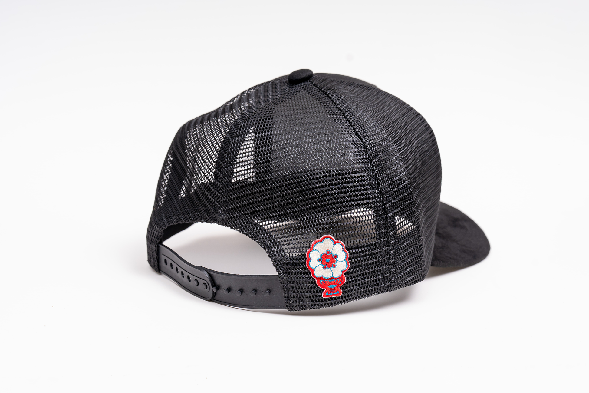 Back view of black trucker hat showing breathable mesh panel
